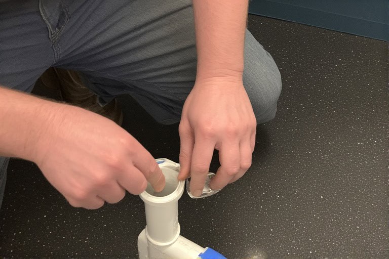 Licensed plumber connecting PVC fittings during cleanout installation in Baton Rouge